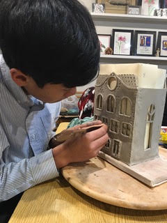 Student holding a bright cityscape painting